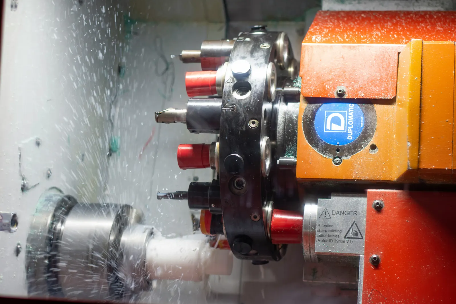 CNC turning tool cutting a cylindrical metal ring on a lathe